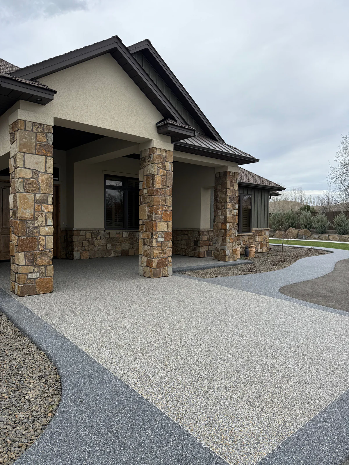 Resin-bound natural stone surface installed across a residential front entry and walkway