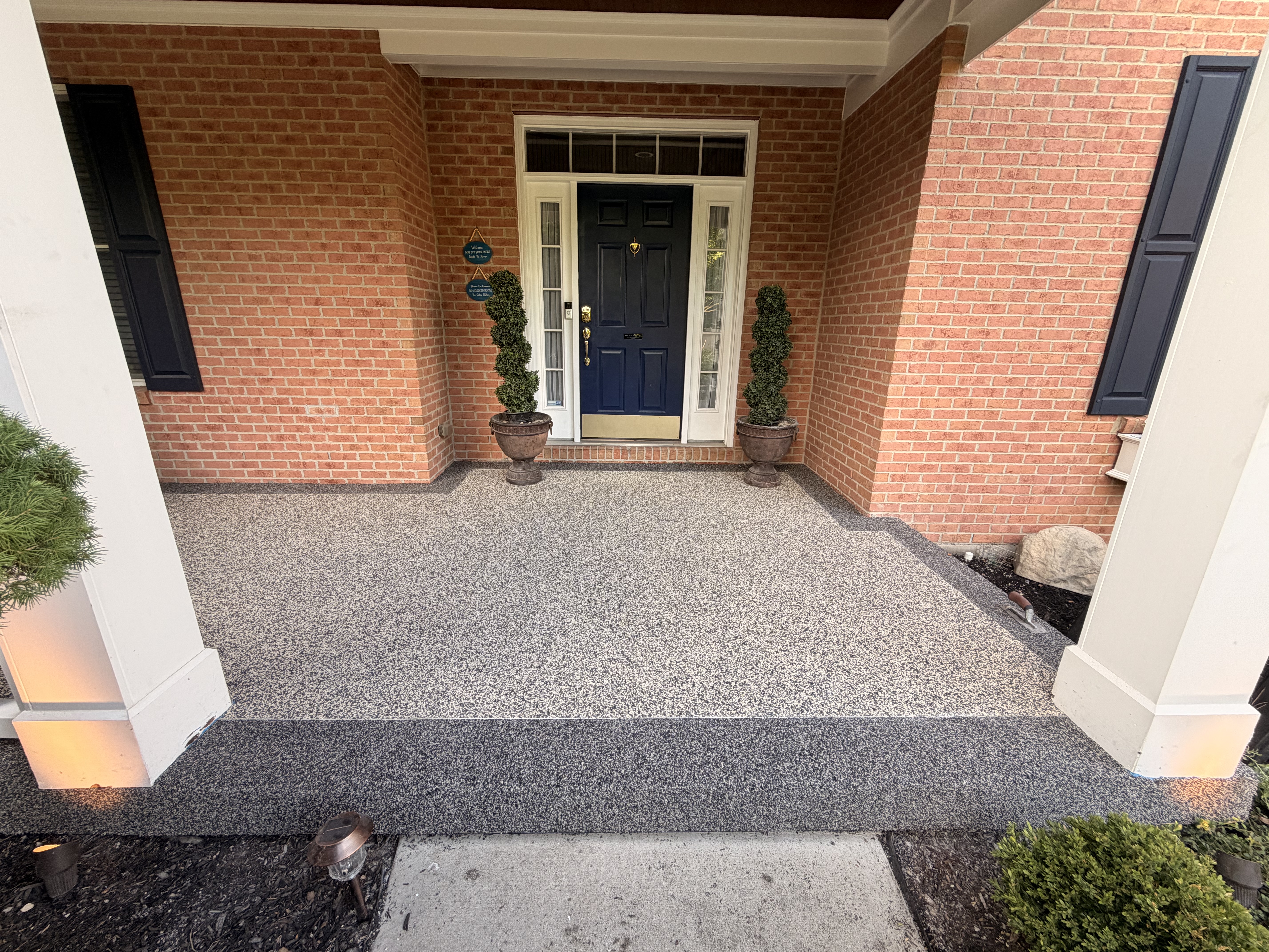 Mason covered front porch after resin-bound stone install at the front entry